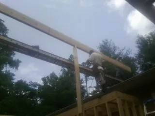 Carpenter setting a ridge beam over a new addition frame — Ice Dam Removal by Roofing Brothers in West Bridgewater