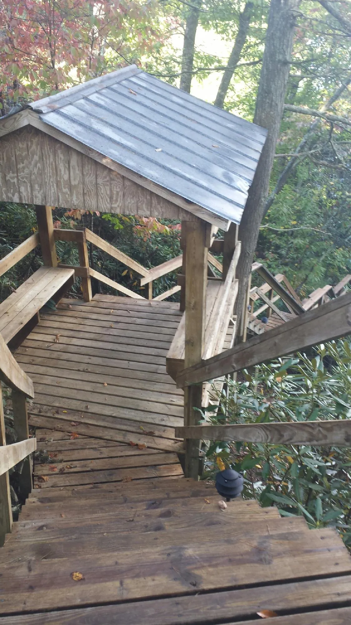Metal roofed shelter over wooden steps on a wooded walkway — Skylight Repair & Installation work by our crew in West Bridgewater