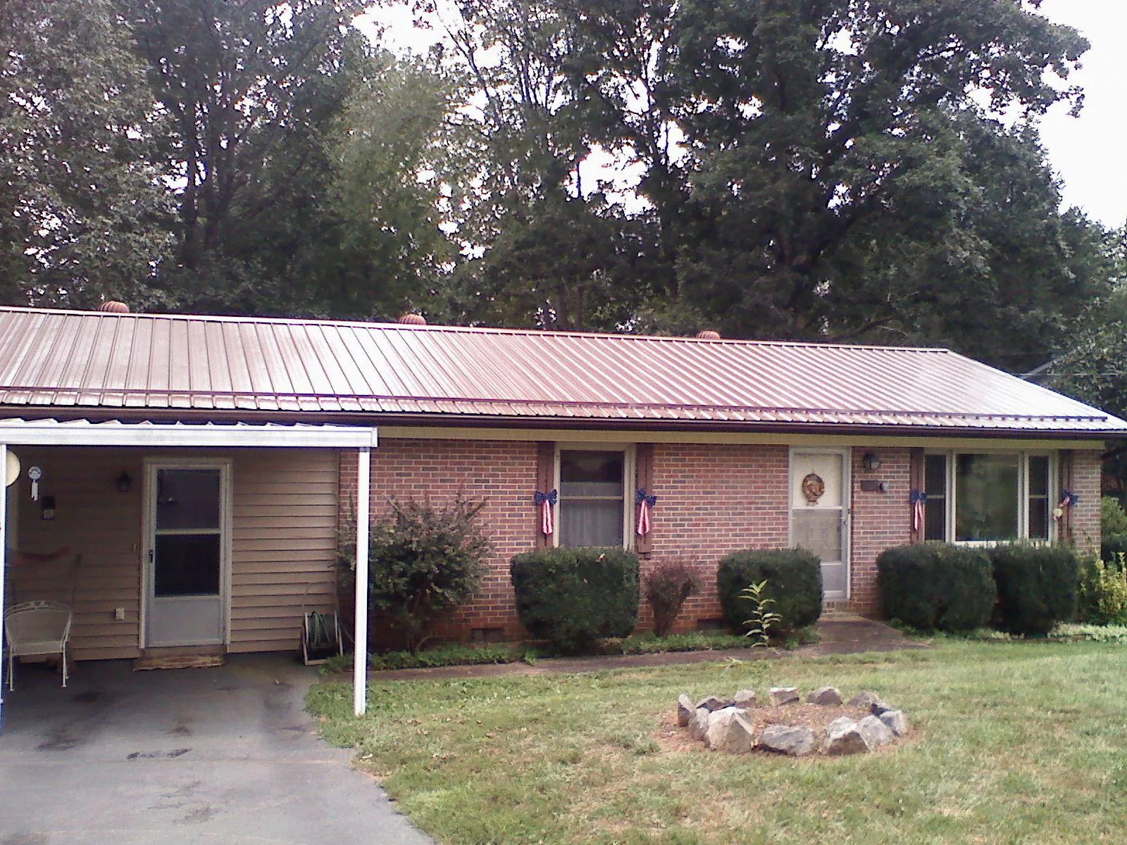 Bronze metal roof and carport on a brick ranch home — Roof Repair work by our crew in West Bridgewater